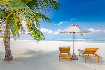 Beach chairs with umbrella on paradise beach island with ocean view. Luxury summer travel destination and vacation or holiday concept design. Tropical beach landscape