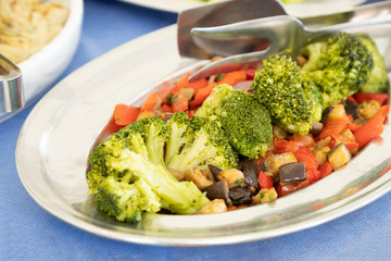 Breakfast buffet in hotel restaurant. Tray of broccoli, zucchin and tomatoes