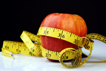 An apple with measuring tape, fitness concept