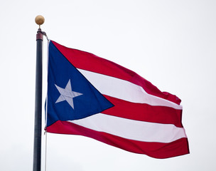 Flag of Puerto Rico waving against blue sky