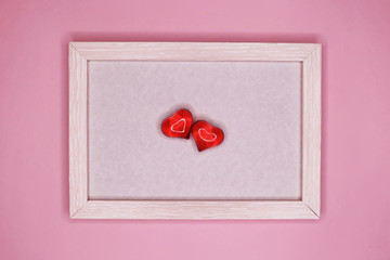 Empty frame and hearts on a pink pastel background. March 8, February 14, Valentine's Day card, Women's Day, holiday concept.