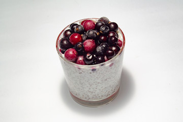 healthy breakfast of chia yogurt seeds and wild berries on a white background fitness food. copy space