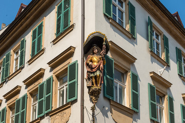 Bamberg, Germany - July 14, 2019; Exterior of an white house with a statue on the corner in the...