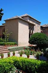 Pretty gardens with the Torre de Maldonado of the Nasrid Palace at the Malaga castle to the rear, Malaga, Spain.