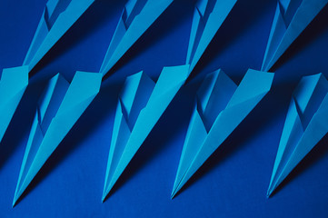 A lot of blue paper planes on a classic blue background.