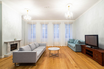 Living room with furniture and fireplace in apartment. Modern interior in light tones.