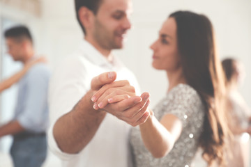 Young couple dancing at party, focus on hands