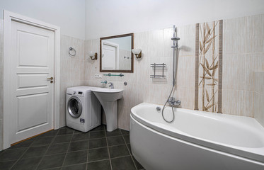 Naklejka na ściany i meble Modern interior of bathroom in light tones with black tile on the floor. Bath, sink, washing machine.