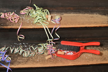 confetti and ribbons on wood steps and a dust pan - cleaning up after the party