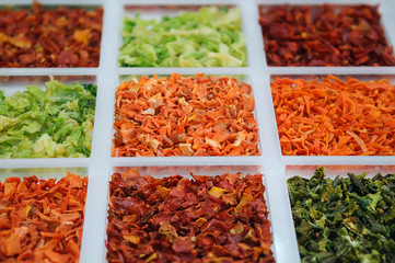 Set of fragrant dried spices and vegetables with selective focus. Parsley, peppers, greens, carrots, paprika and tomato dried vegetables and herbs.