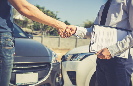 Customers shake hand with car insurance agents to enter into friendly terms and conditions, Car crash on the road concept.