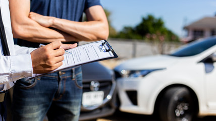 Insurance agents inspect for damage to cars that collide on the road to claim compensation from driving accidents, Insurance concept.