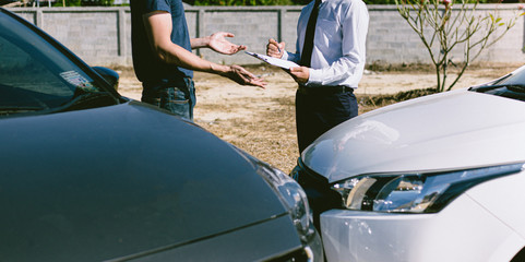 Insurance agents inspect for damage to cars that collide on the road to claim compensation from...