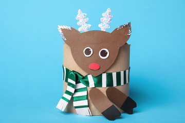 Fototapeta premium Toy deer made of toilet paper roll on light blue background