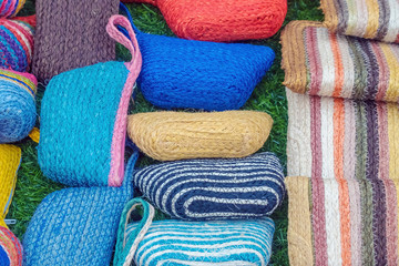 Close up to vintage handicraft colorful bags by yarn for sale at local market in Thailand. Selective focus.