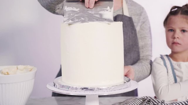 Step by step. Frosting round funfetti cake with white italian buttercream frosting.