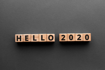 Fototapeta na wymiar Hello 2020 - word from wooden blocks with letters, happy new year hello 2020 concept, gray background