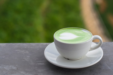 Hot green milk tea in white cup