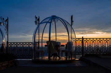 Restaurant with sea view. Table for two under a glass dome with a view of the sunset by the sea.