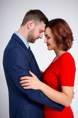 Valentine's day and love concept - portrait of cute elegant couple hugging over white