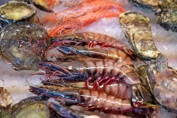 Shrimps and oysters shells on the ice, sea food on the market.