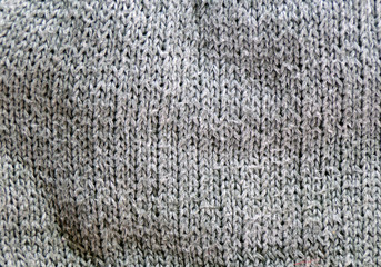 Texture of knitted fabric. Grey background of knitted yarn.