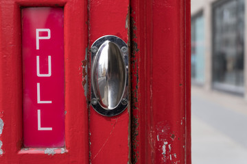 Close up of red phone box handle with pull text