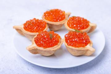 Naklejka na ściany i meble Red caviar (salmon caviar) in tartlets. Selective focus, close-up.