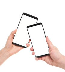 Two hands holding smartphones blank screen with modern frameless design while wireless transferring data NFC connected isolated on white background