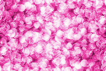 Pink bokeh shiny glitter background. Abstract vibrant color glowing white spots texture for graphic design.