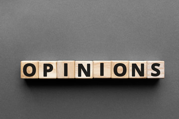 Opinions - word from wooden blocks with letters, a thought or belief about something opinion concept, top view gray background