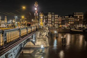 Blauwbrug historic bridge in Amsterdam over the river Amstel illuminated at night