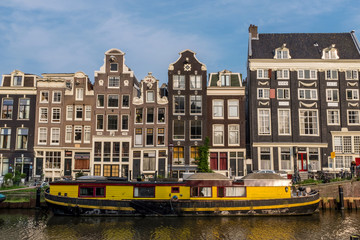 Yellow canal boat on the Singel Canal in Amsterdam