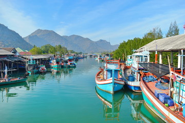 Fototapeta na wymiar Colourful boats on river. The picturesque river landscape. Pier with beautiful wooden boats. River in mountains in the tropics.