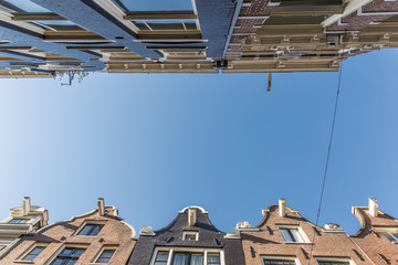 Dutch houses in narrow streets of Amsterdam viewed from below