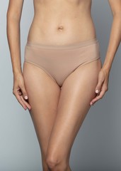  Woman in beige panties on a gray background