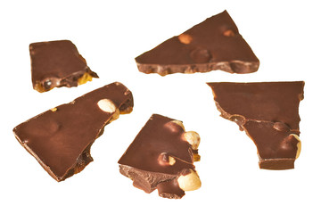 Scattered pieces of rectangular chocolate bar with peanut and raisin isolated on white background