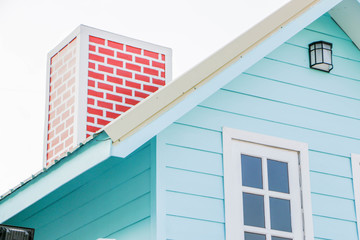 The roof of the blue house and red chimney