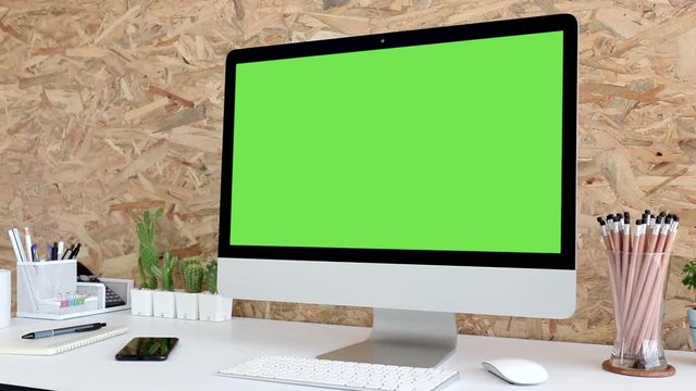 Computer desktop with mock-up green screen white background  in office and  Lovely cactus in brown pot , Zoom shoulder view.