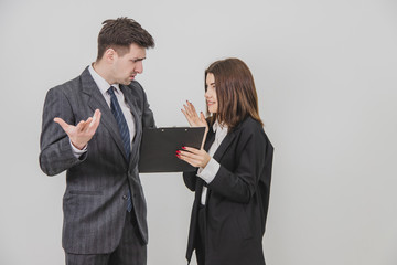 Cute young secretary brought document, which boss has to sign, but he doesn't understand and don't want to sign, frowning.