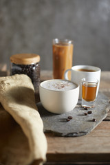 Hot coffee cup and coffee beans on wooden table..