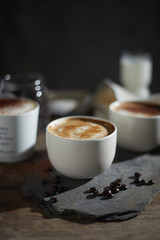 Hot coffee cup and coffee beans on wooden table..