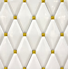 Detail texture of white ceramic tiles with gold accents. Background, texture
