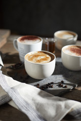 Hot coffee cup and coffee beans on wooden table..