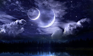Night sky and double moon on a fabulous cloudy sky