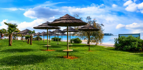 Fototapeta na wymiar Beautiful coast of Porec with parasols on the beach promenade