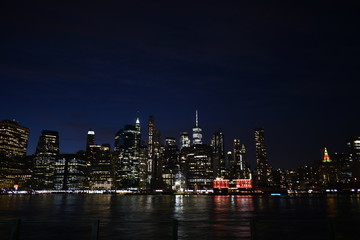 Fototapeta premium New york skyline from brooklyn at night with water reflection