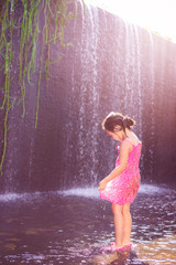 little asian girl playing water in spillway of weir