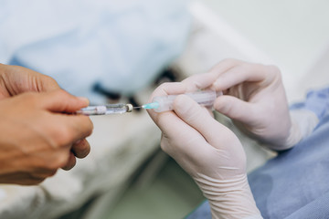03.09.2019 Kyiv, Ukraine: a professional team of surgeons injects a vaccine or medicine into the syringe to add it to the patient's drip. Selective focus, noise effect.