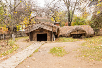 Plakat Authentic peasant underground an thatched roof farms and houses in Dimitrie Gusti National Village Museum, located in the King Michael I Park, showcasing traditional Romanian village life